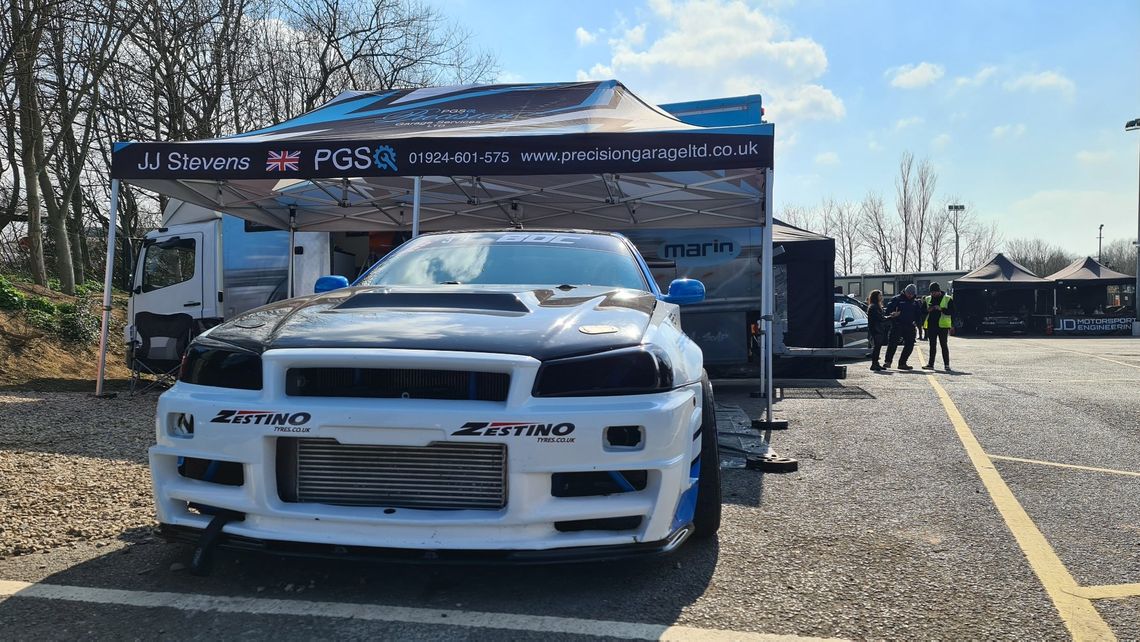 A drift car beneath a printed pop up gazebo