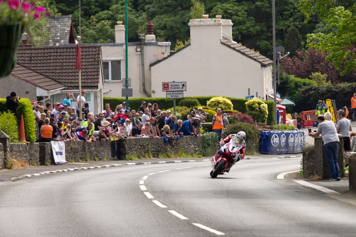 A motorcycle races around a corner at the Isle of Man TT race