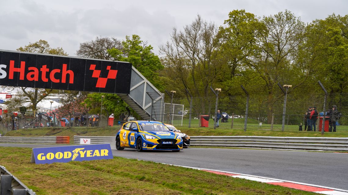 A BTCC car drives under the bridge at Brands Hatch circuit