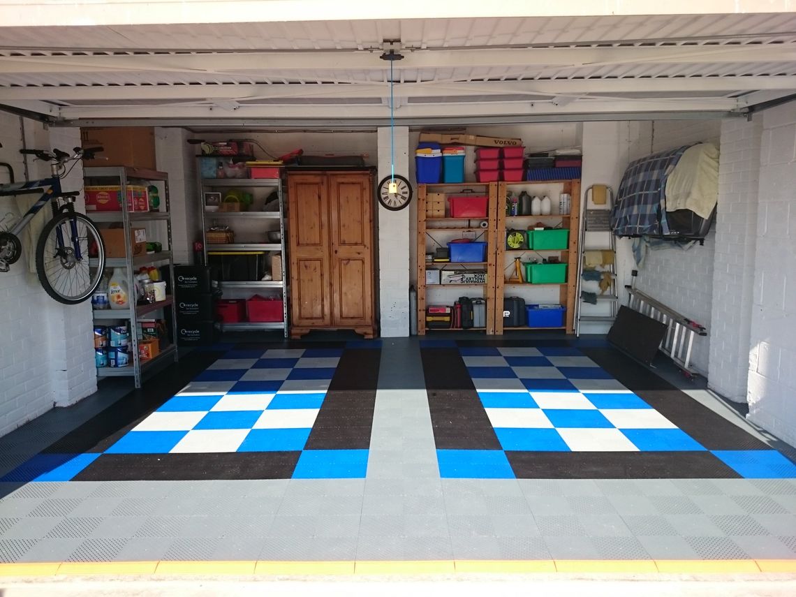 A home garage with swisstrax flooring in black, white and blue