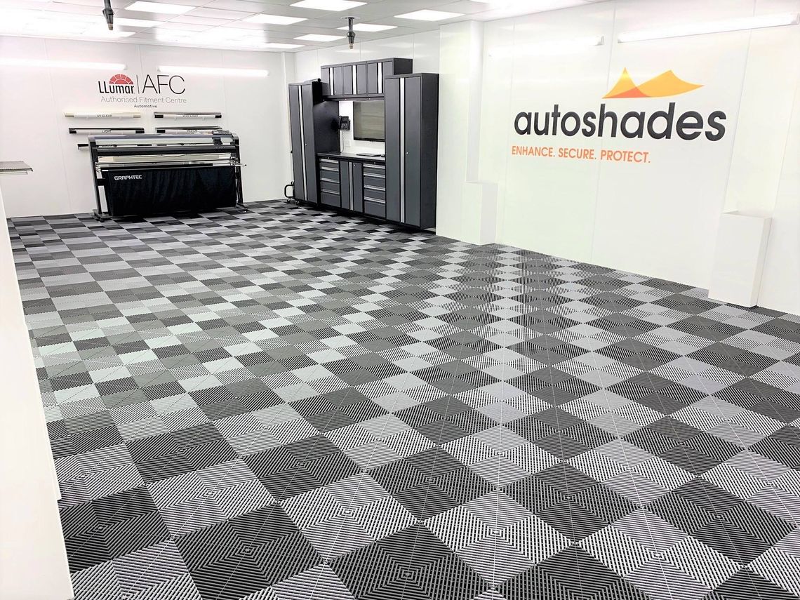 A professional detailing workshop with white walls and chequered swisstrax uk flooring