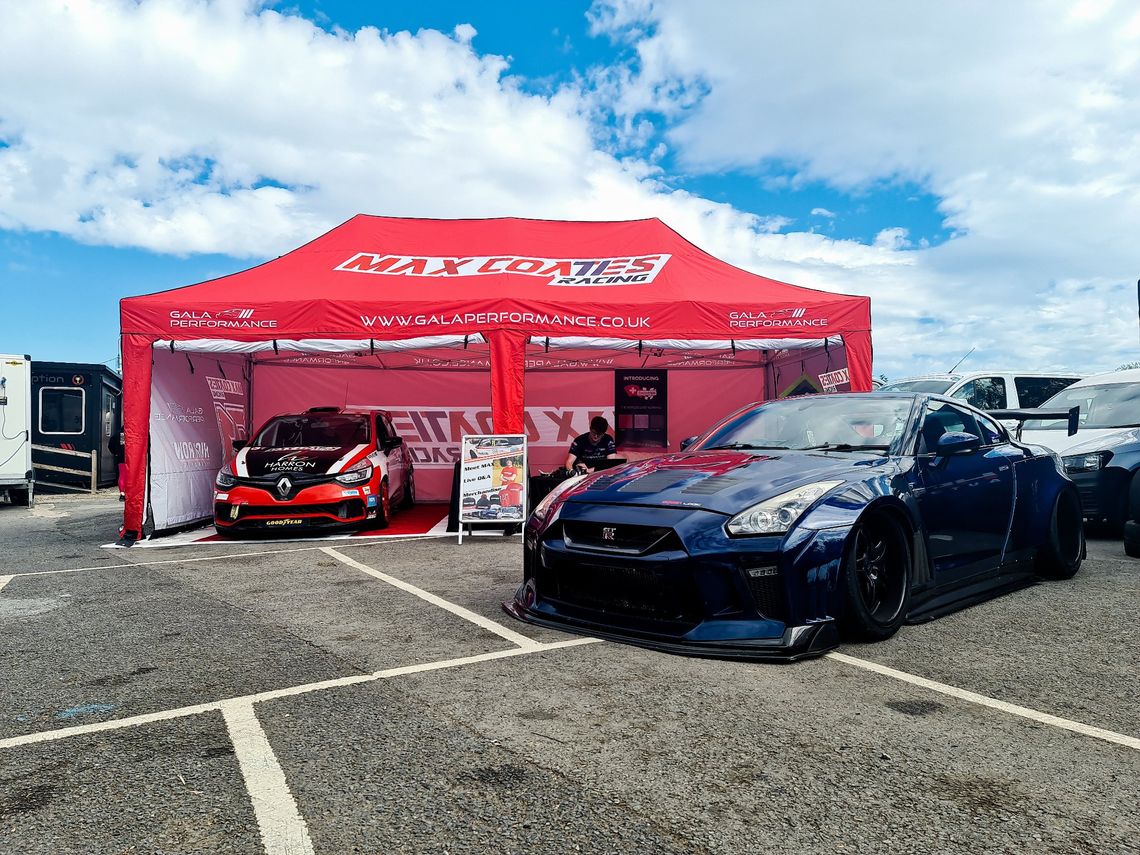 A red pop up motorsport tent with a black car