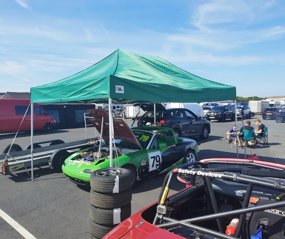 motorsport green race car under green gala performance pit tent