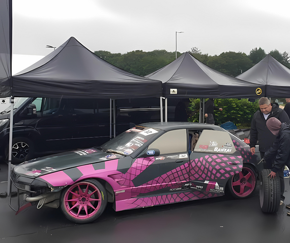 pink and black drift car in motorsport paddock gala performance gazebo